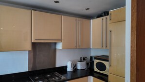 A compact kitchen with a gas stove, oven, microwave, and a toaster. - Modern and super cosy apartment, peaceful location, Richmond London (Richmond)