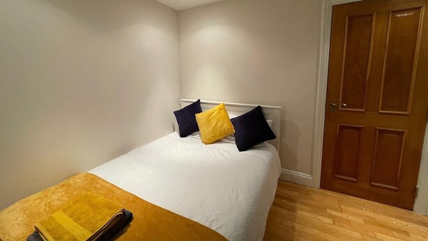 A bedroom with a bed, a wooden door, and a light fixture on the ceiling. - Modern and super cosy apartment, peaceful location, Richmond London (Richmond)