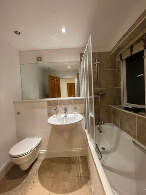 Ein Badezimmer mit Toilette, Waschbecken und Badewanne.