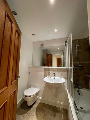 A bathroom with a toilet, sink, mirror, and shower. - Modern and super cosy apartment, peaceful location, Richmond London (Richmond)