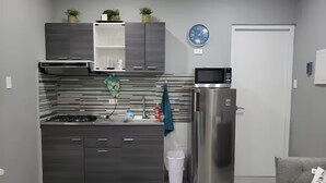 Eine moderne Küche mit Einbauherd, Mikrowelle und einem Edelstahl-Kühlschrank.