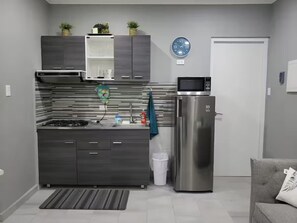 Eine moderne Küche mit Einbauherd, Mikrowelle und einem Edelstahl-Kühlschrank.