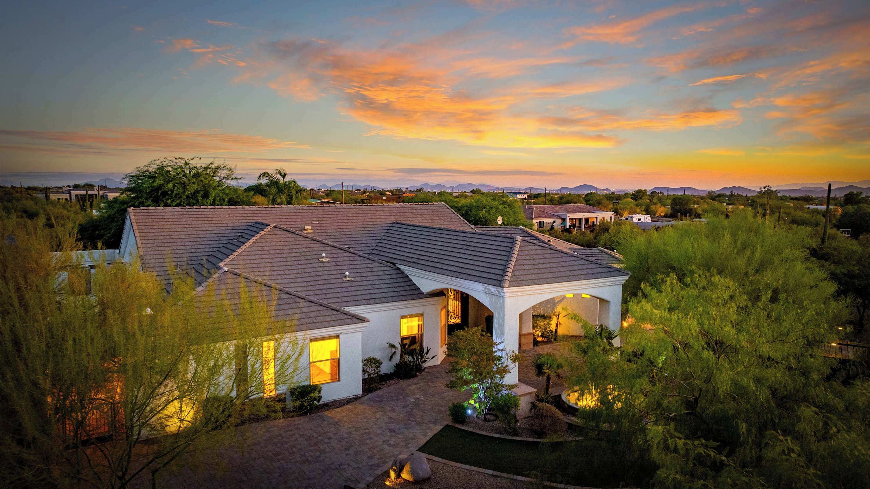 A large house with a covered patio and a driveway.