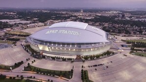 En arena med ett stort, böjt tak och texten ”AT&T Stadium” på det.
