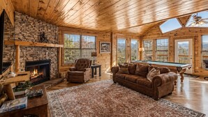 A cozy cabin interior with a fireplace, a pool table, a leather sofa, and a large rug. - Honeymoon VIEW! Beautiful romantic cabin, great location & hot tub w/epic view! (Sevierville)