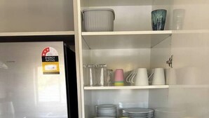 A kitchen with a stainless steel refrigerator, a built-in cabinet with glassware, plates, and bowls. - 53 Snowmass Dr - Ohakune Retreat w/ Ruapehu View (Ohakune)