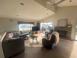 A modern living room with a sofa set, a coffee table, a fireplace, and a television. - 53 Snowmass Dr - Ohakune Retreat w/ Ruapehu View (Ohakune)
