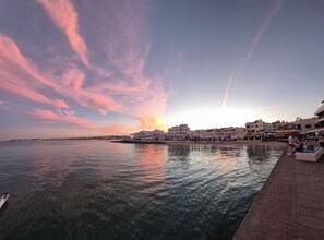 A waterfront view with buildings, a clear sky, and calm water. - Dream in Paradise - Ocean Views & AC (Corralejo)