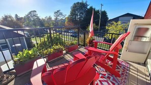 A balcony with red chairs, a red table, and potted plants. - Family Cottage-House in Scenic James Bay, Victoria: 1 Blk to Ocean & Ogden Pt! (Victoria)