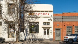 A building with a sign that reads 'EAT IN OR TAKEAWAY' and 'WELCOME TO MISSION DISTRICT.' - Elmrise in Elsternwick (Saint Kilda East)