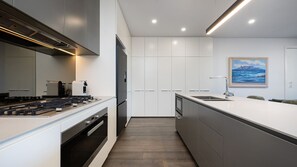 A modern kitchen with a built-in oven, a stove, and a sink. - Elmrise in Elsternwick (Saint Kilda East)