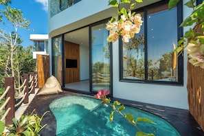 Una casa moderna con piscina, ventanas amplias y terraza de madera.