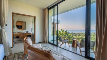 Ein modernes Schlafzimmer mit einer großen Glasschiebetür, die auf einen Balkon mit Meerblick führt.