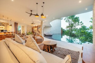 Un interior moderno con comedor, asientos y vistas a un paisaje natural.