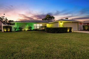 Ein modernes Haus mit Solaranlage, Garage und gepflegtem Rasen.