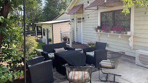 An outdoor patio with a sofa set, chairs, and a small table. - Equestrian cottage— country living in the city (Aiken)