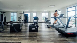 Academia com esteiras, aparelhos de musculação e pesos livres.