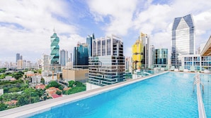 Piscina no terraço com horizonte urbano ao fundo.