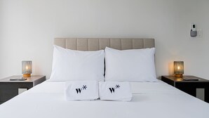Ein Bett mit zwei Kissen, jedes mit einem 'W' und einem Sternchen.