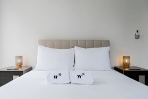 Ein Bett mit zwei Kissen, jedes mit einem 'W' und einem Sternchen.