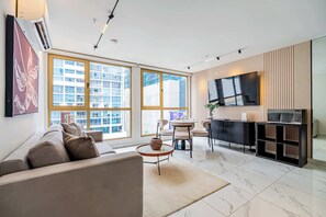 Una sala moderna con sofá, una mesa de centro y un comedor con sillas.