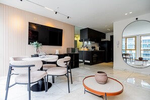 Une cuisine moderne avec un coin repas, un grand téléviseur et une vue sur la ville.