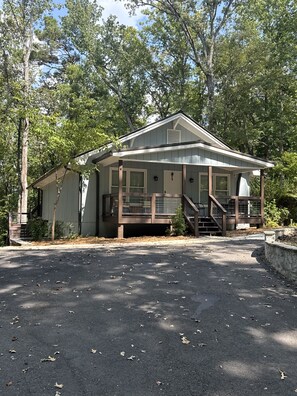A two-story building with a porch, a staircase, and a small attached shed.