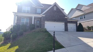 A two-story residential house with a garage, a front lawn, and a sidewalk. - Charming 3-bedroom house pleasant Dallas (dallas)