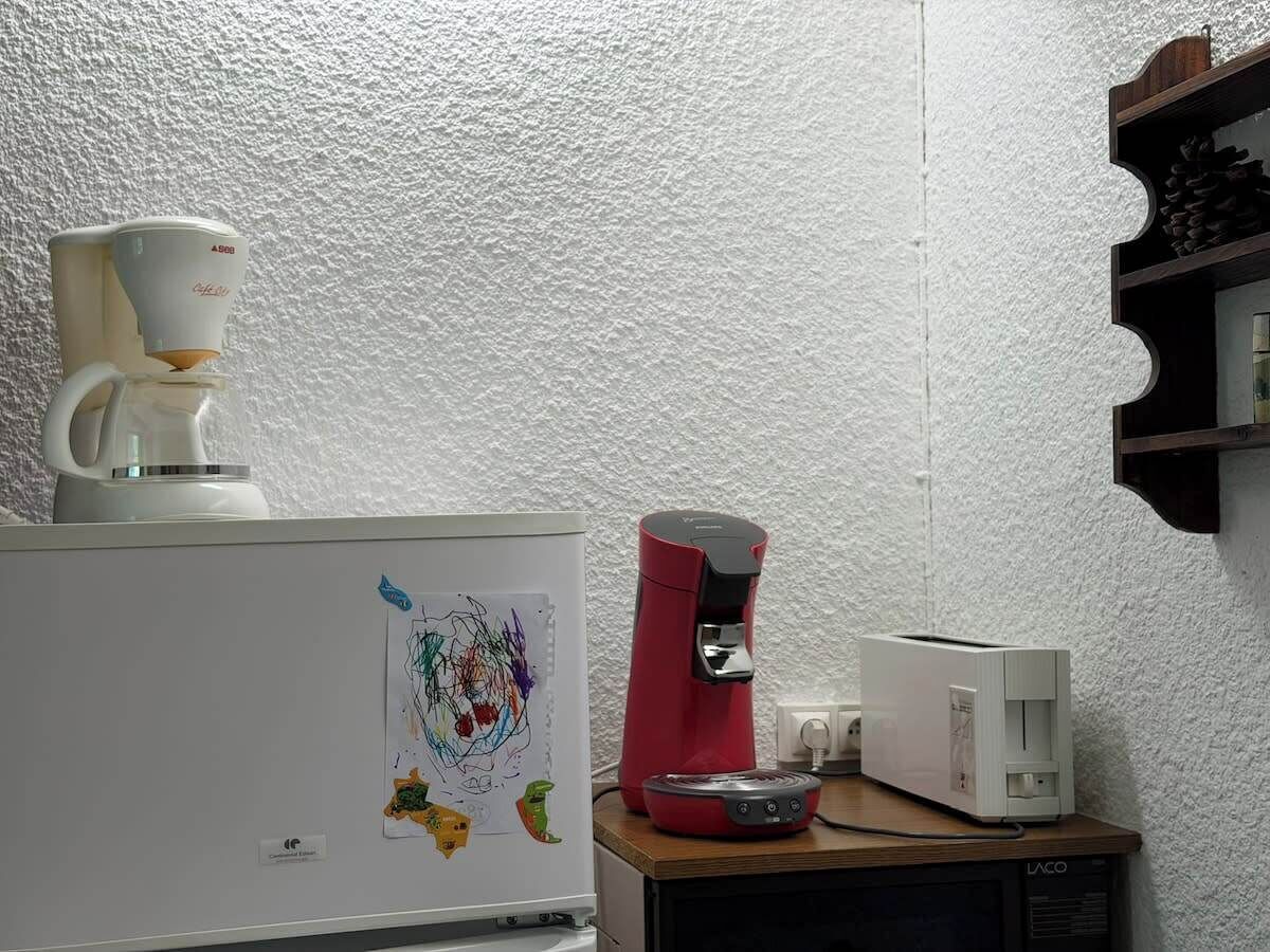 Une petite cuisine équipée d’une machine à café, d’un grille-pain et d’un réfrigérateur.