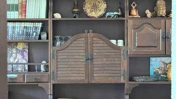 Ein Bücherregal mit Büchern, Dekorationen und einem zentralen Holzschrank.