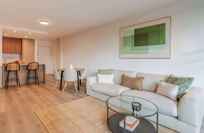 Ein modernes Wohnzimmer mit einer Couch, einem Couchtisch und einem Essbereich mit Stühlen und einem Tisch.