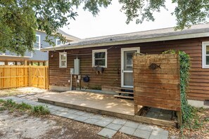 A wooden house with a front porch, a fenced yard, and a wooden deck. - Pet-Friendly Oak Island Home W/ Fenced Yard &Fire Pit (Oak Island)