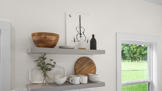 A kitchen with white cabinets, a wooden bowl, a vase with greenery, and a window with a view of greenery. - Hidden Gem Farm-Two Tiny Homes-Sleeps 11 (Spring Hill)