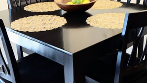 A dining table with a bowl of fruit in the center, surrounded by four chairs. - New Gated Home Near the Texas Medical Center: Workspace + Yard +Fast Wifi (Houston)