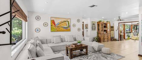 A spacious living room with a large sofa, a coffee table, and decorative items.