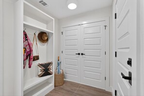 A hallway with white walls, a white door, and a white wardrobe with black handles. - 3-bedroom brand new modern house in  Dallas with cool AC for relaxing stay (Dallas)