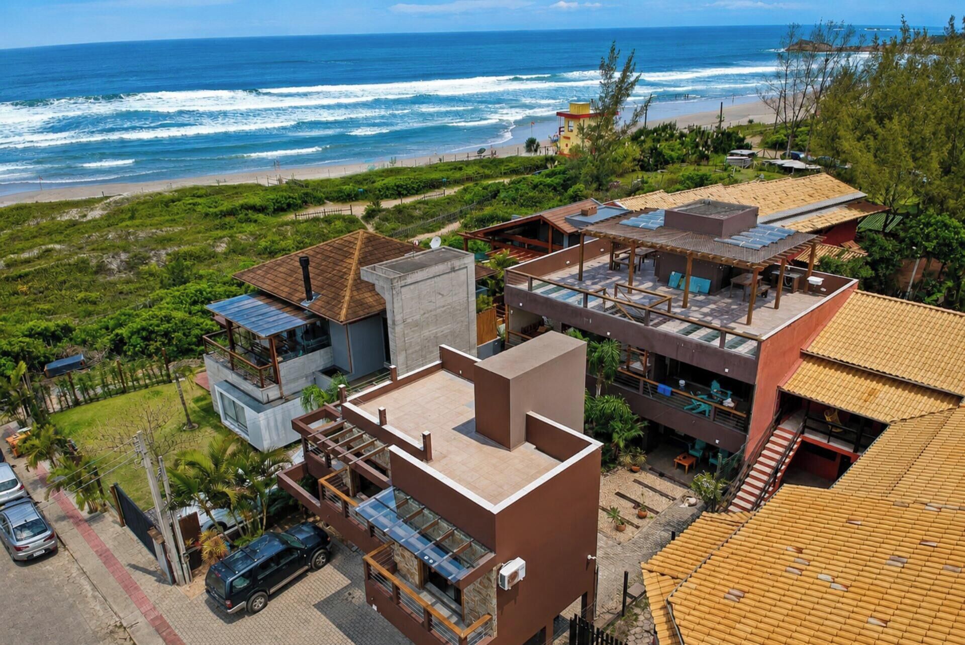 Zona residencial costera con casas modernas, una playa y una torre de salvavidas.