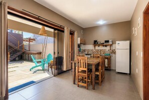 Una cocina compacta con comedor, refrigerador y microondas.