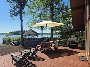 Una terraza con mobiliario exterior, un pabellón y vistas a un lago.