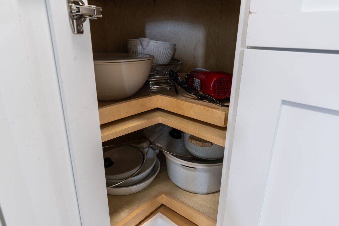 A kitchen with wooden shelves, a red appliance, and various kitchenware.