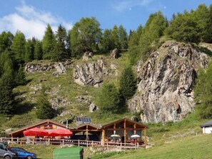 A mountain lodge with outdoor seating and a view of rocky terrain. - Exklusives Architektur-Chalet in toller Lage by Interhome (St-Martin VS)