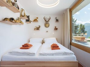 Un dormitorio con cama, dos toallas y vistas a montañas a través de una ventana.
