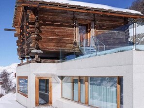 A modern log cabin with a glass balcony and large windows. - Vacation home  by Interhome (St-Martin VS)