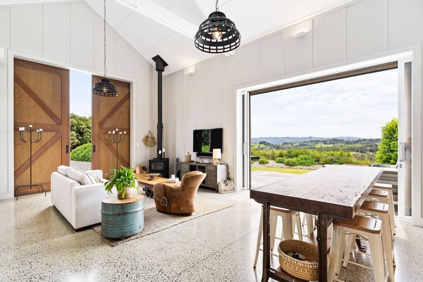 A spacious living room with a large window, a fireplace, and a dining area.