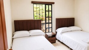 A hotel room with two beds, a wooden nightstand, and a window with a view of greenery. - A peaceful country villa with incredible views (Cundinamarca)