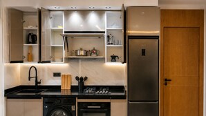 A compact kitchen with a built-in washing machine, oven, and a stainless steel refrigerator. - Modern 1BR Netflix • WiFi • Free Parking (Tangier)