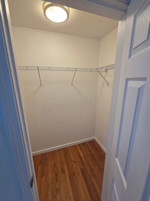 A room with a wooden floor, a white wall, and a ceiling light. - Blue heron INN 3-bedroom home 2.2miles from FLW! (Saint Robert)