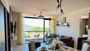 Un soggiorno moderno con zona pranzo, ampie finestre e vista sulla città.