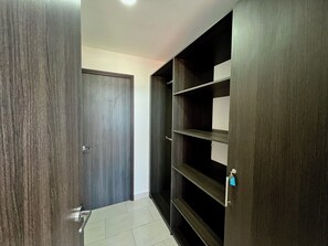 A hallway with a dark wooden door, a metal handle, and a tiled floor. - Cozy 1-bedroom apartment with AC in fantastic San Salvador (San Salvador)