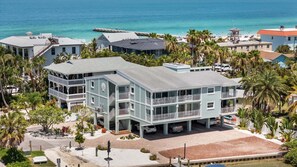Ein mehrstöckiges Strandhotel mit Balkonen, einem Parkplatz und Blick auf den Ozean.